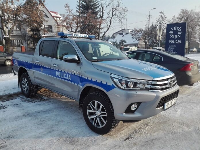 Auto policyjne stojące na parkingu.