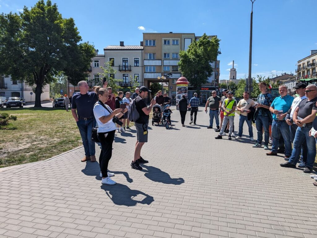 Rolnicy i reporterzy stoją na Placu Sikorskiego w trakcie pikiety