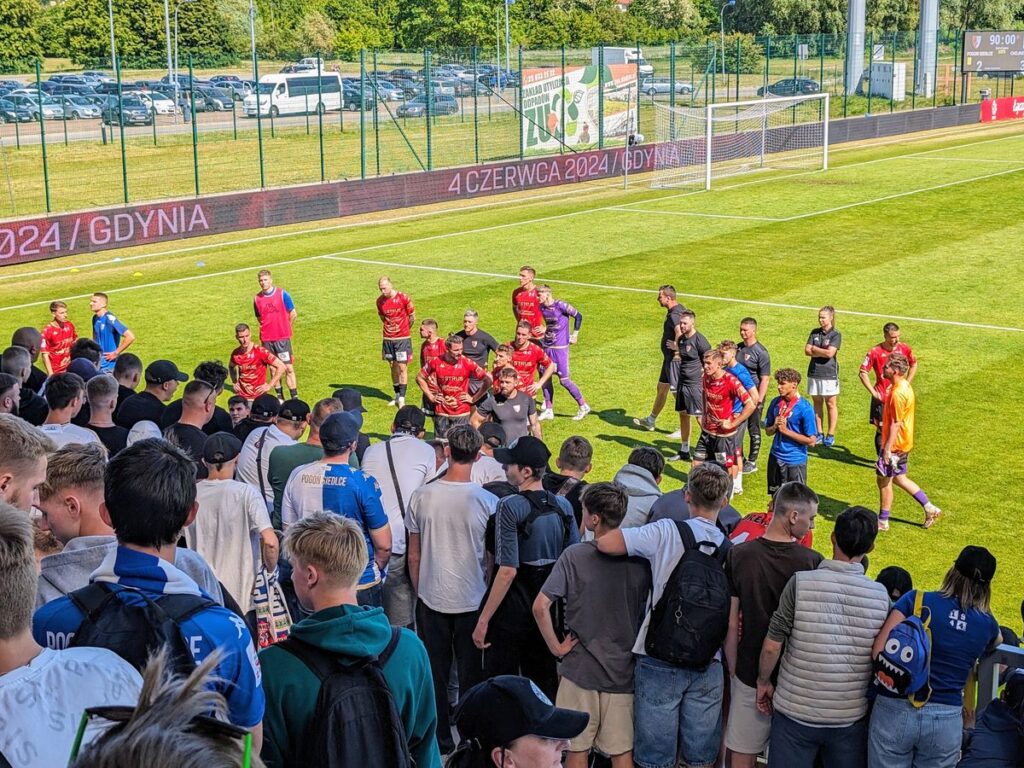 Kibice zespołu Pogoń Siedlce i zawodnicy patrzą na siebie