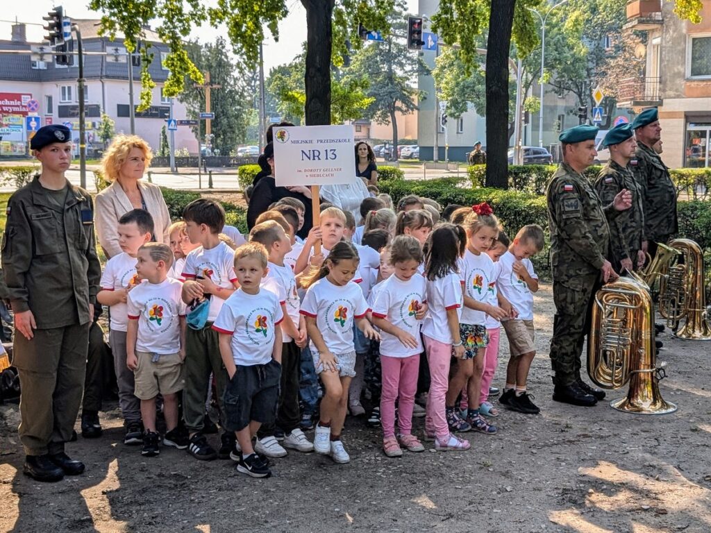 Grupa kilkuletnich dzieci stoi między żołnierzami