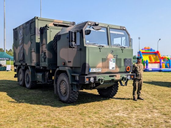 Żołnierz stoi przy dużym pojeździe wojskowym