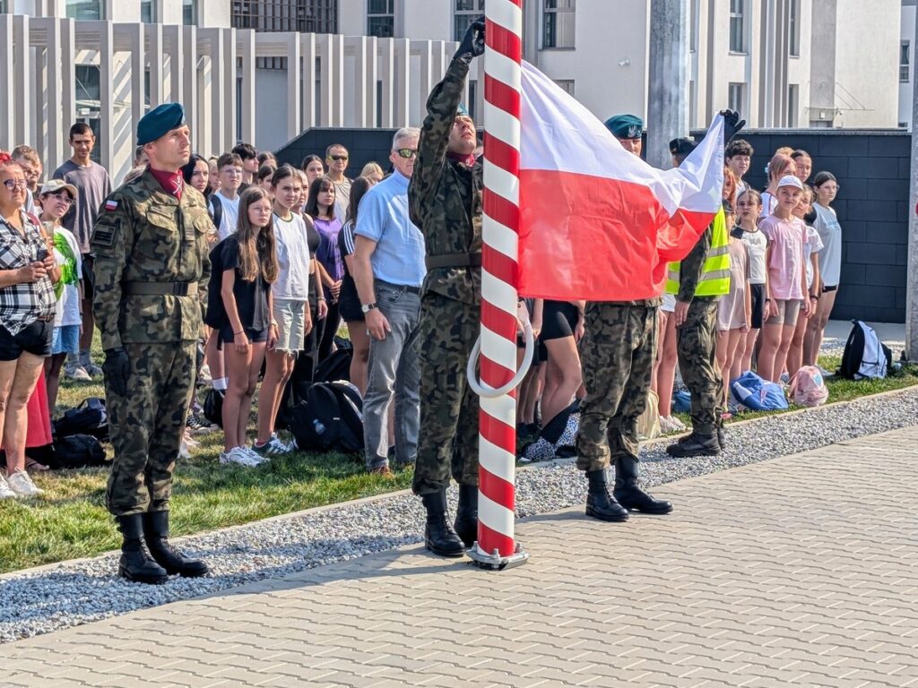 Żołnierze zawieszają flagę państwową na maszt