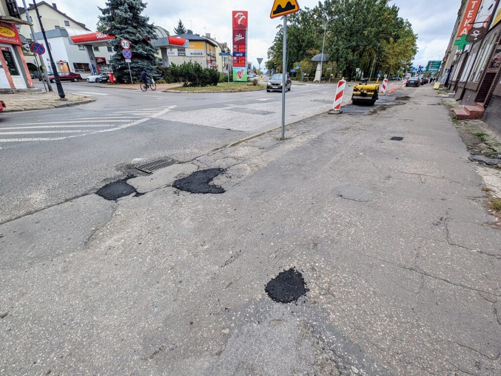 Małe dziury w asfalcie na chodniku wypełnione nową warstwą, nieestetyczny widok. 