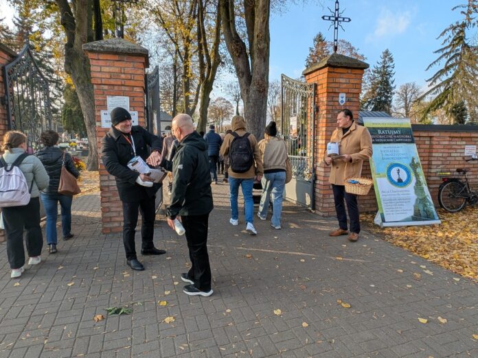 Dwaj mężczyźni stoją z puszkami przed wejściem na cmentarz