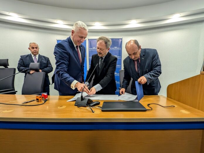 Trzej mężczyźni przeglądają dokumenty przy stole konferencyjnym