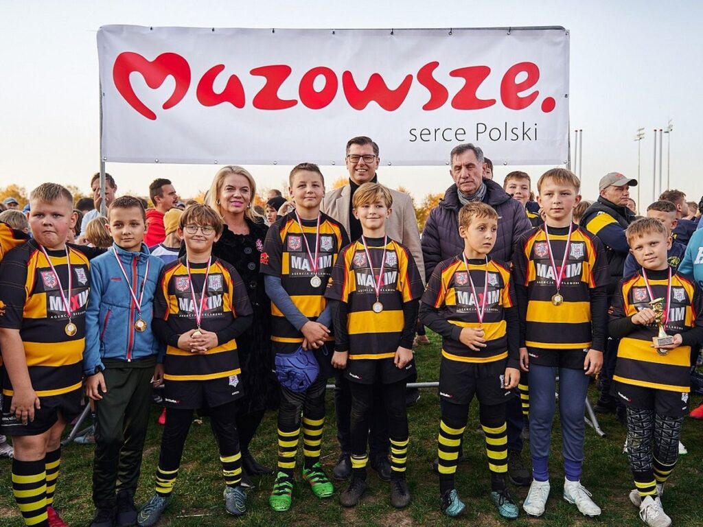 Grupa nastoletnich zawodników rugby patrzy w obiektyw 