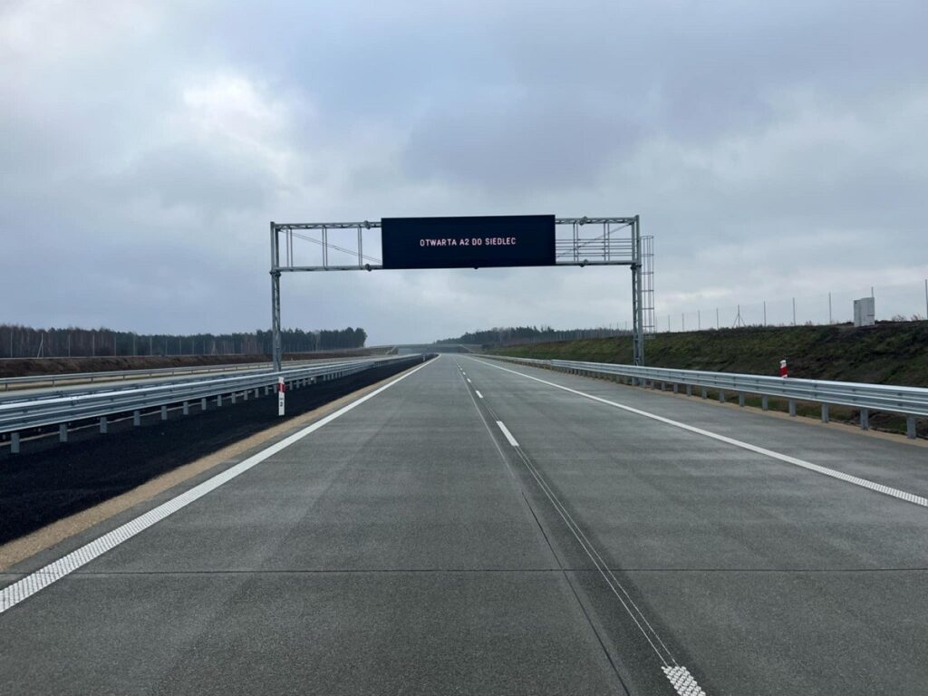 Widok na autostradę i bramkę nad nią z napisem "Otwarta A2 do Siedlec". 