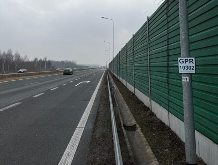 Autostrada z tablicą informacyjną o Generalnym Pomiarze Ruchu z widocznymi ekranami akustycznymi