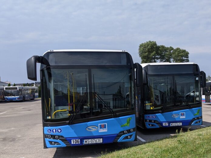 Dwa autobusy miejskie w niebieskich kolorach stojące na parkingu